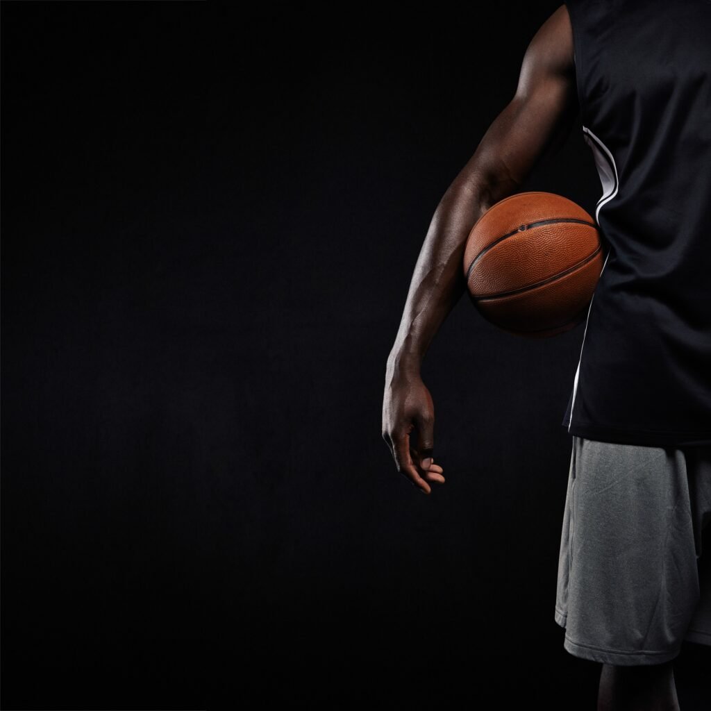 Black basketball player standing with a basket ball