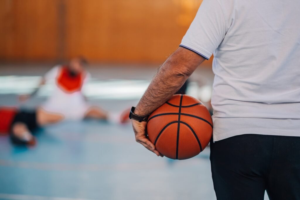 Cropped picture of basketball trainer holding a basketball on training.